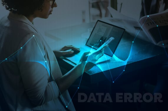 Personne travaillant sur une tablette et un ordinateur portable avec une visualisation de données en surimpression et le texte 'DATA ERROR', symbolisant une erreur d’analyse ou de traitement des données.
